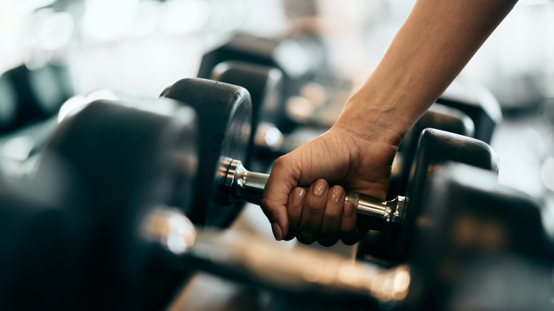 hand picking up a dumbell