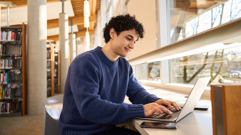 young man working on a computer in a library