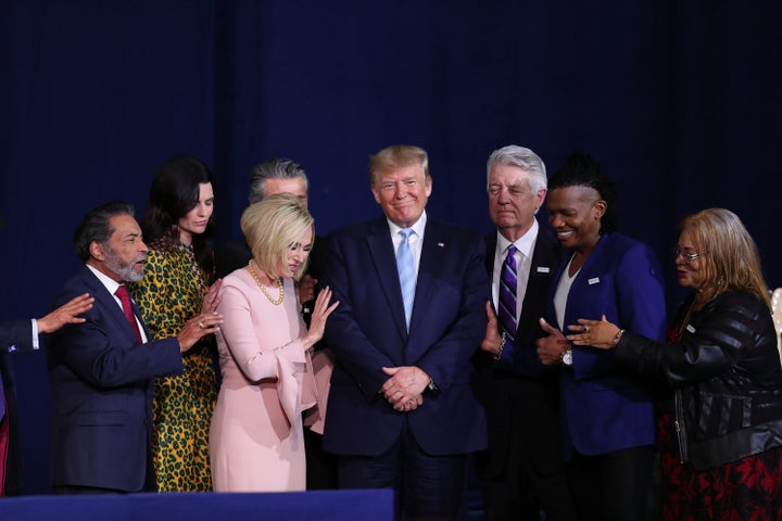 Faith leaders pray over President Donald Trump during a 